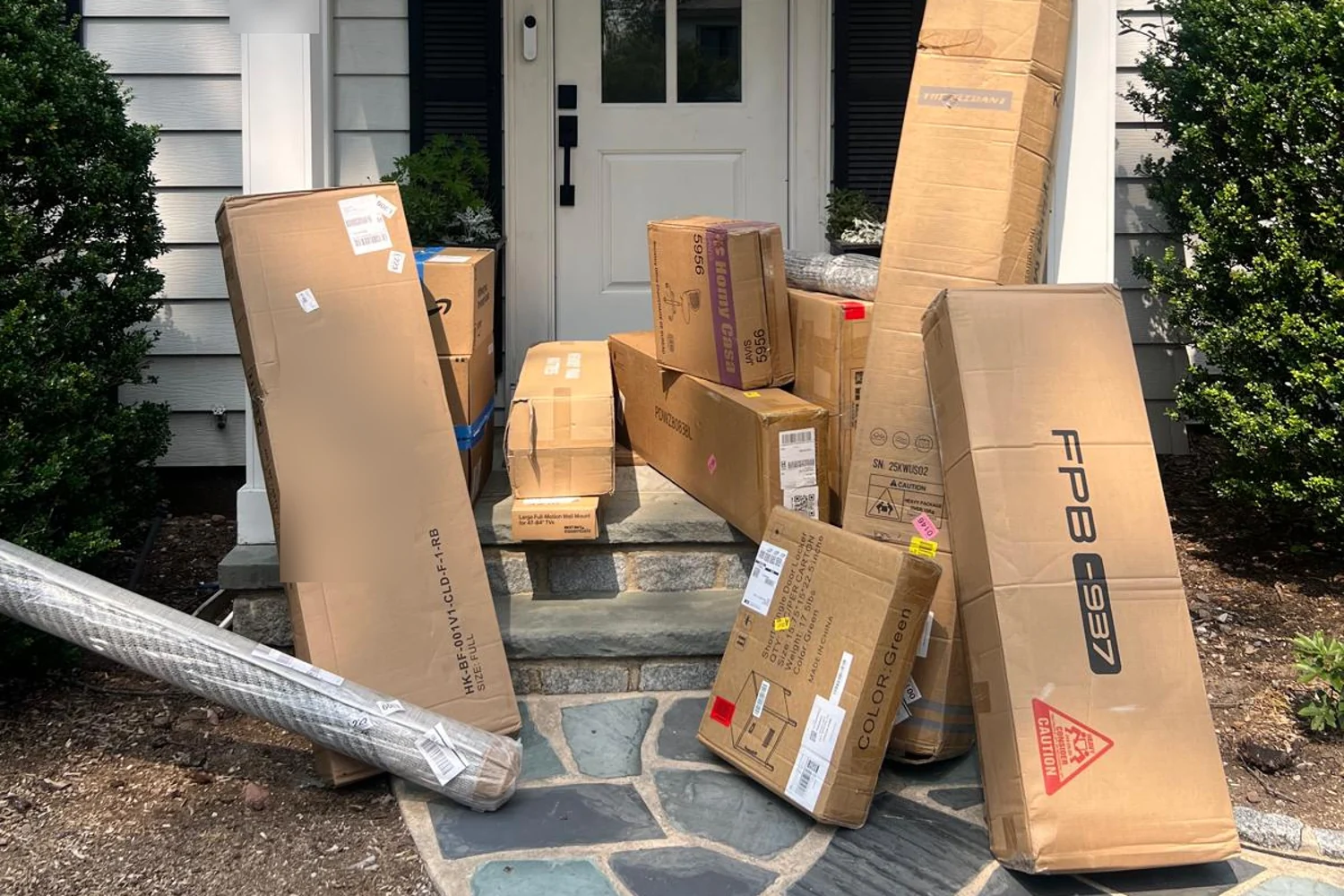 Furniture and household deliveries stacked at the front door of a house