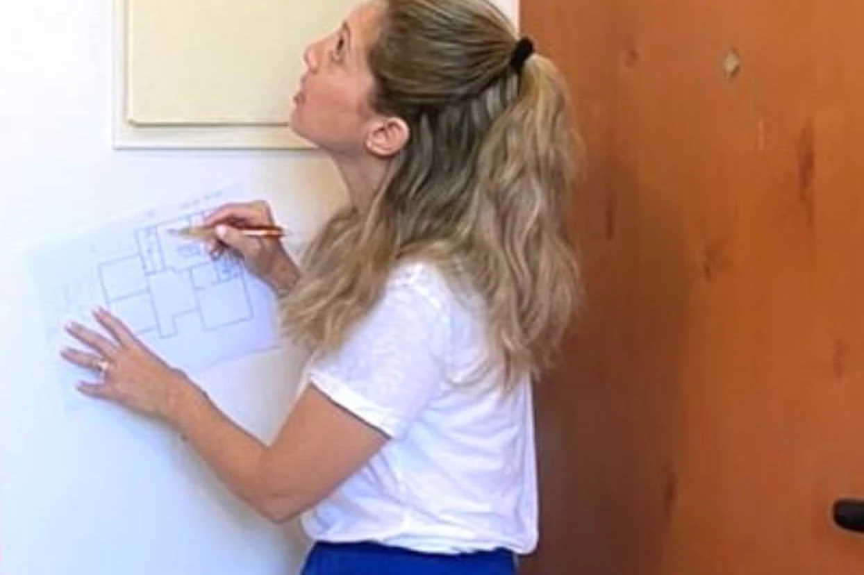 Adi marking up a floor plan against the wall during a site measure